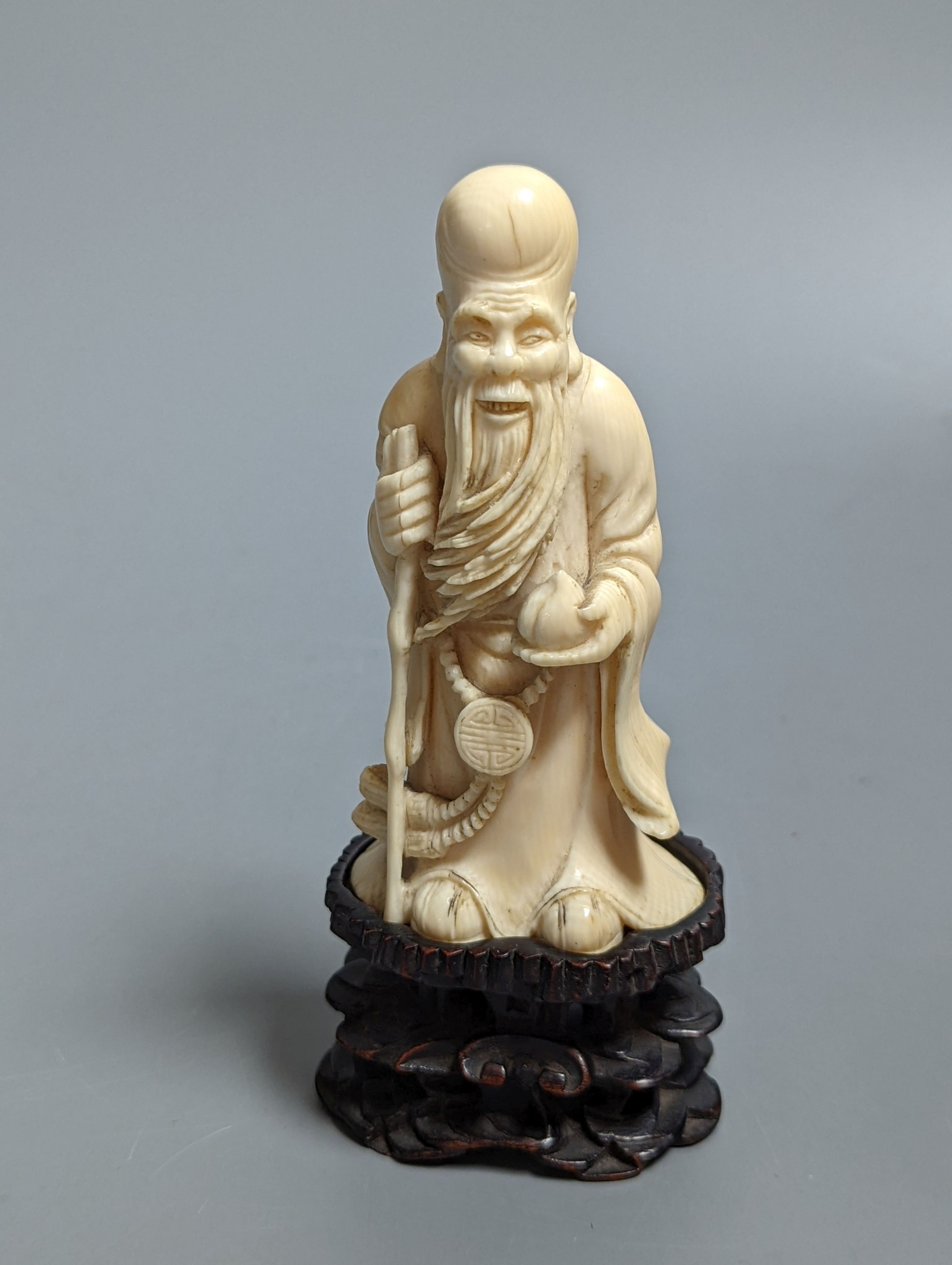 An early 20th century Chinese carved ivory figure of Shao Lao on stand and a jade figural carving 13cm
